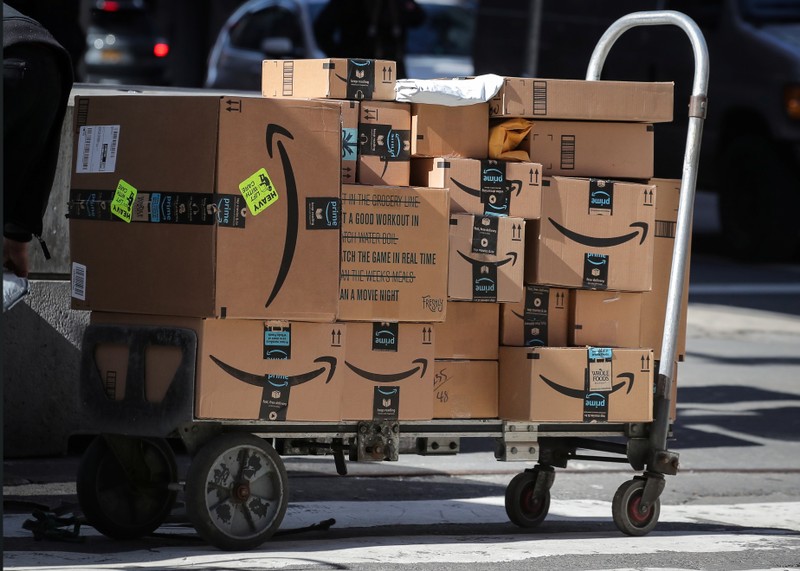 Amazon boxes are stacked on a delivery cart in New York