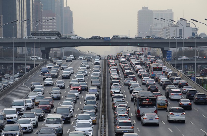 Cars drive on a main road through Beijing's central business area