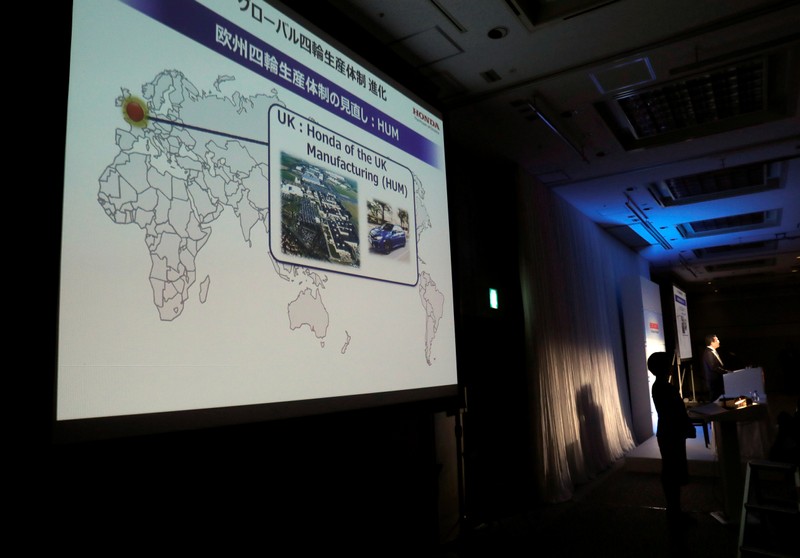 An image about Honda's British factory is projected while Honda Motors Chief Executive Takahiro