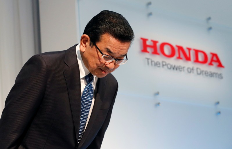 Honda Motor Chief Executive Takahiro Hachigo bows his head as he arrives at a news conference