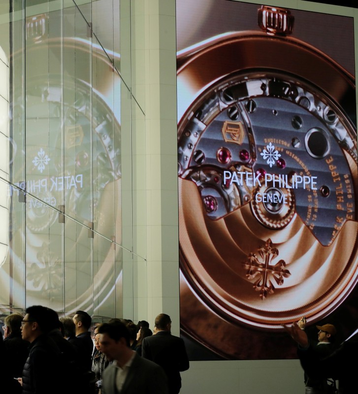 Visitors are seen in front of the exhibition stand of Swiss watch manufacturer Patek Philippe