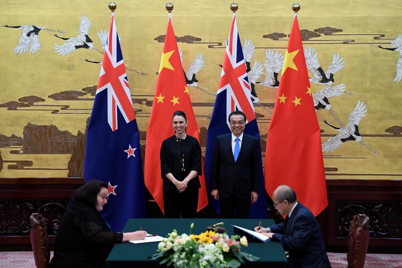 New Zealand Prime Minister Jacinda Ardern and Chinese Premier Li Keqiang attend a signing