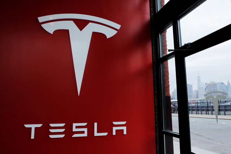 FILE PHOTO: A Tesla logo is painted on a wall inside of a Tesla dealership in New York