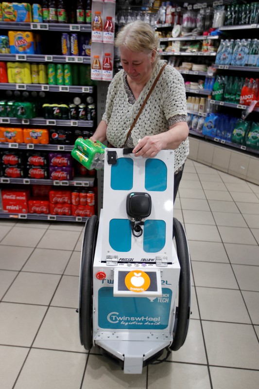 A woman does her shopping at a store using an autonomous robot, shaped and inspired by Star