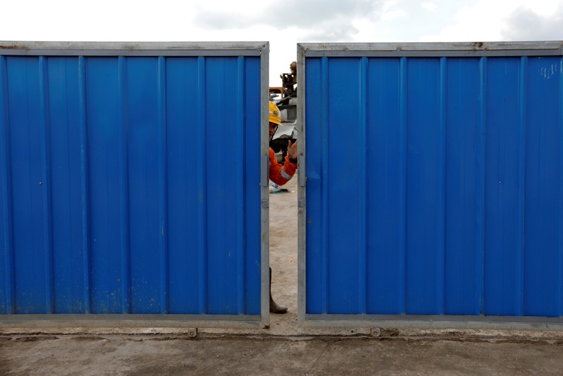A worker closes the gate at Walini tunnel construction site for Jakarta-Bandung High Speed