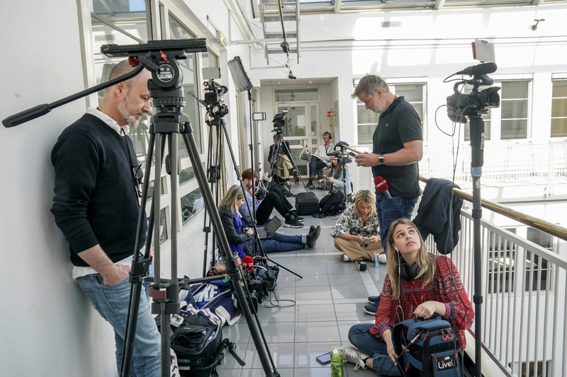 Reporters and photographers gather outside the office of Norway's national mediator after