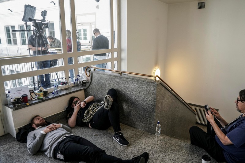Reporters and photographers gather outside the office of Norway's national mediator after