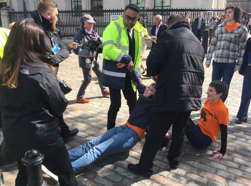 Climate change protesters are dragged away by security outside Barclays annual investor meeting