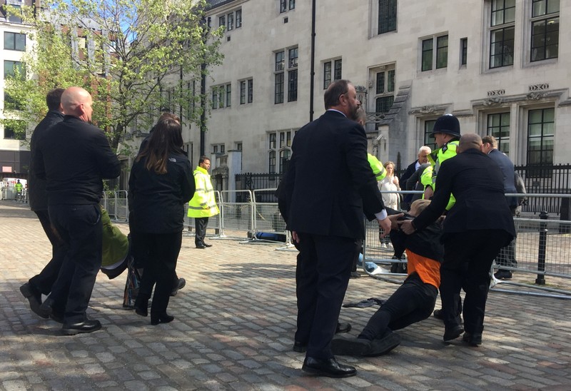 Climate change protesters are dragged away by security outside Barclays annual investor meeting