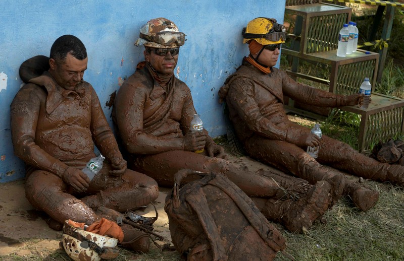 FILE PHOTO: Members of a rescue team react upon returning from the mission, after a tailings