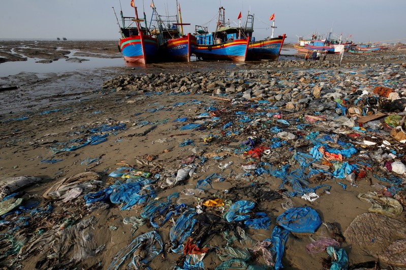 FILE PHOTO: Fishing boats are seen at a beach covered with plastic waste in Thanh Hoa province