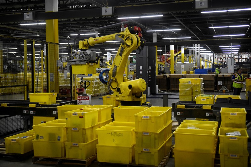 FILE PHOTO: Six-axis robot arm picks up sorting containers at the Amazon fulfillment center in