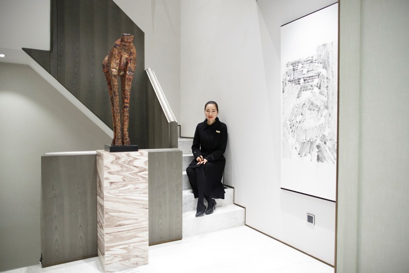 Property saleswoman Zhao Na poses for pictures in a upscale showroom apartment in Zhengzhou