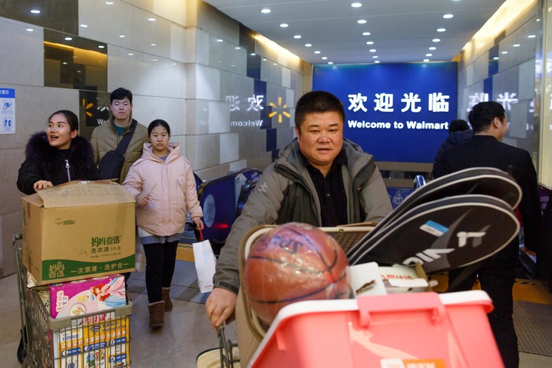 People push shopping trolleys at a Walmart in Zhengzhou