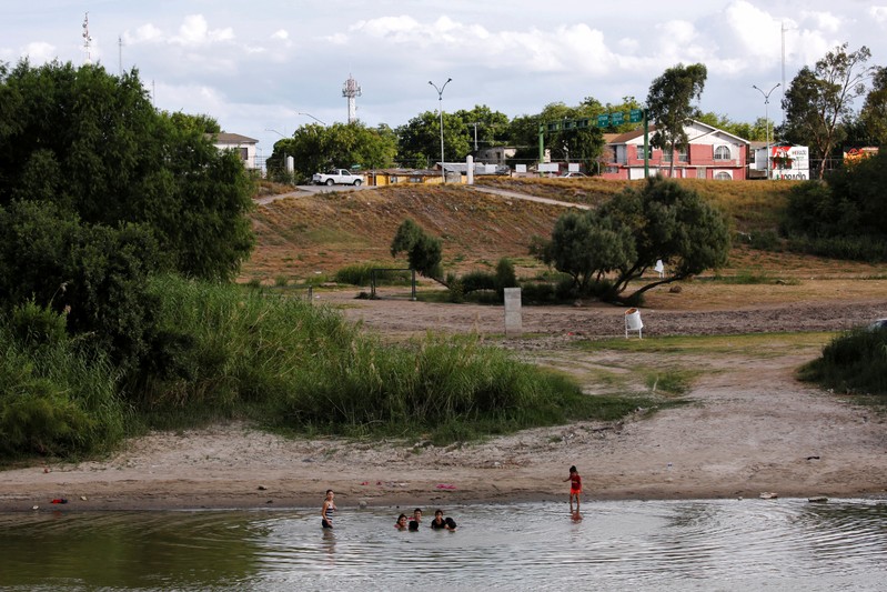 Mexicans enjoy the afternoon on the shore of Rio Bravo near the border as seen from Laredo,