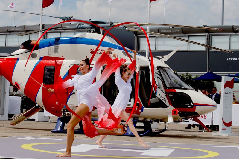 Artists perform in front of a Russian multi-purpose Ansat helicopter during the 53rd