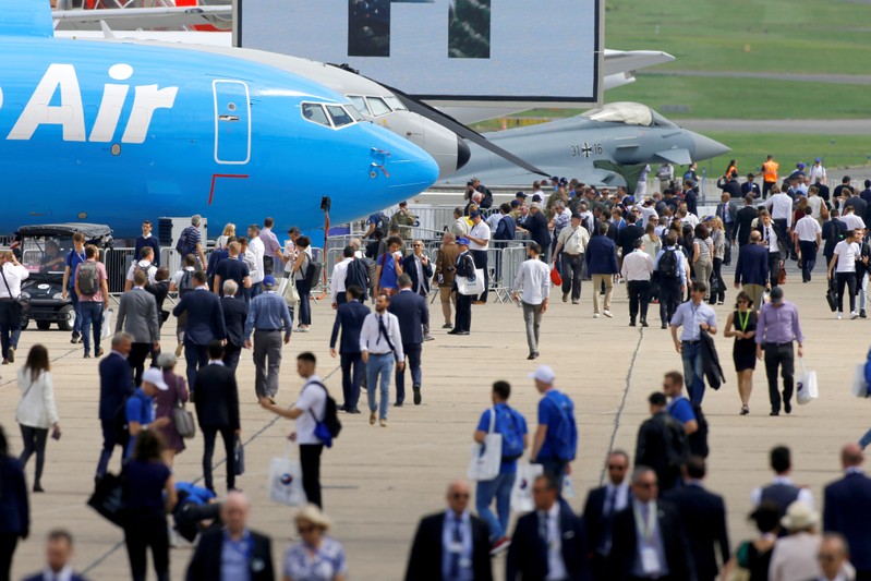Visitors walk past during the 53rd International Paris Air Show at Le Bourget Airport near