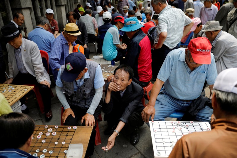 Elderly people play Chinese chess at a park in Seoul