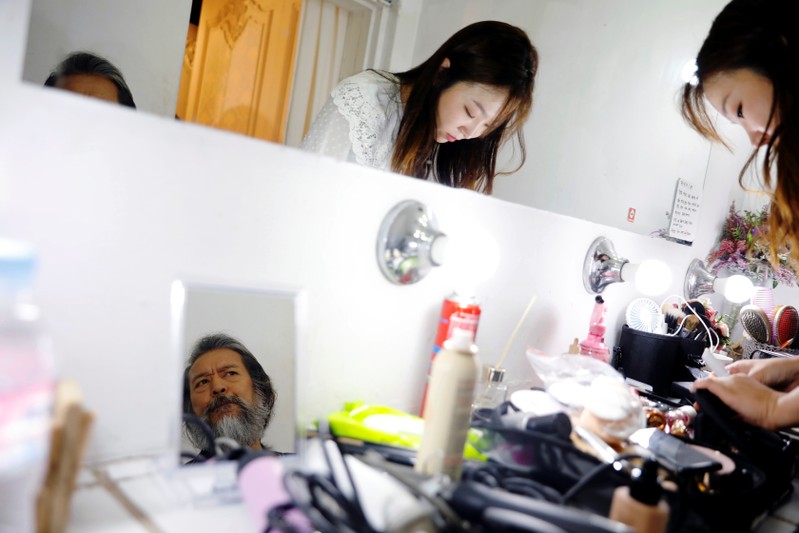 South Korean senior model Kim Chil-doo, 65-years-old, gets his makeup done as he prepares for a