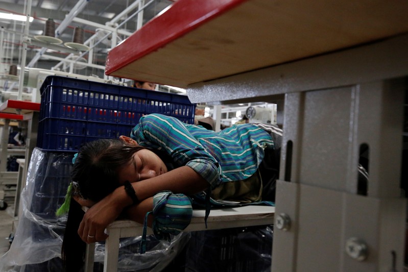 A worker take a nap during lunch break at  Yakeda Outdoor Travel Products Co. LTD in Yangon,