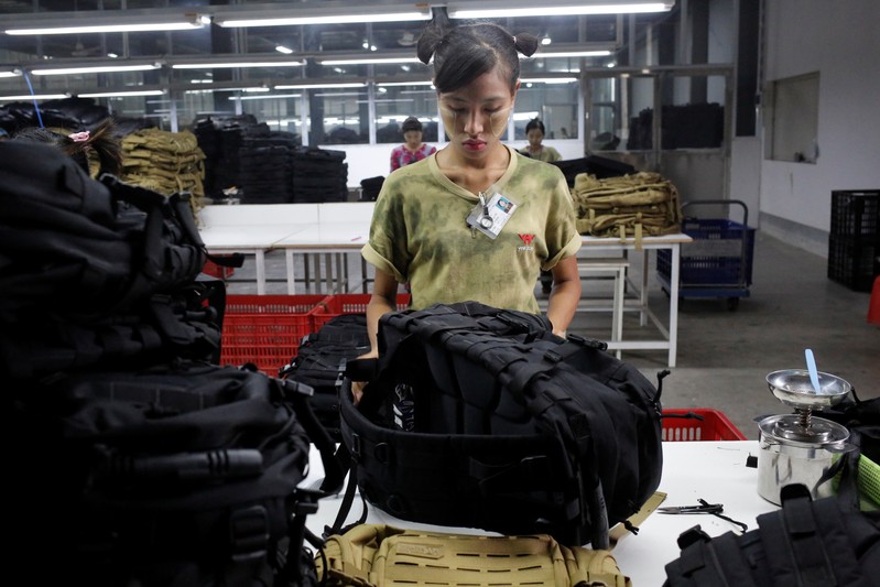 Workers assemble products at a factory owned by Yakeda Outdoor Travel Products Co. LTD in