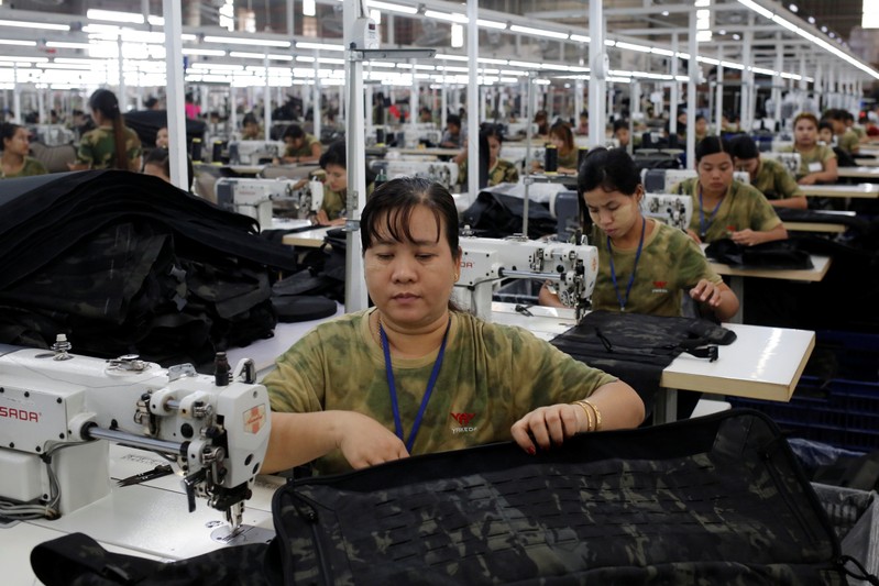 Workers assemble products at a factory owned by Yakeda Outdoor Travel Products Co. LTD in