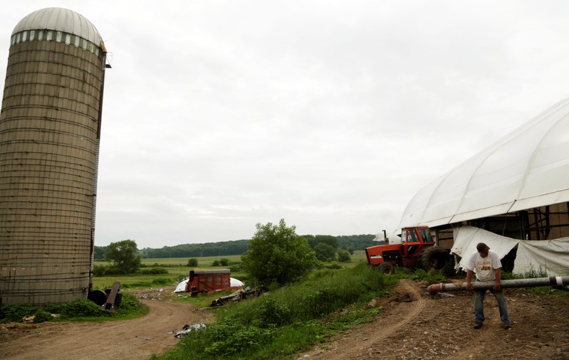 Gordon A. Giese and his son Paul Giese get ready to fill a manure tank at the family farm, God