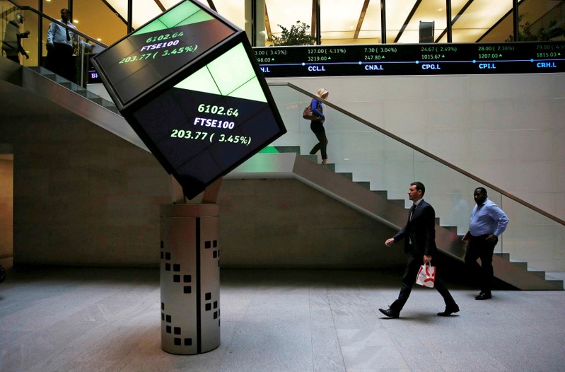 People walk through the lobby of the London Stock Exchange in London