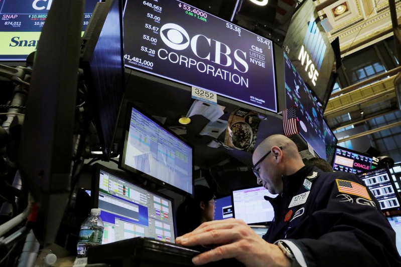 FILE PHOTO: A trader works below the CBS Corporation logo on the floor of the New York Stock