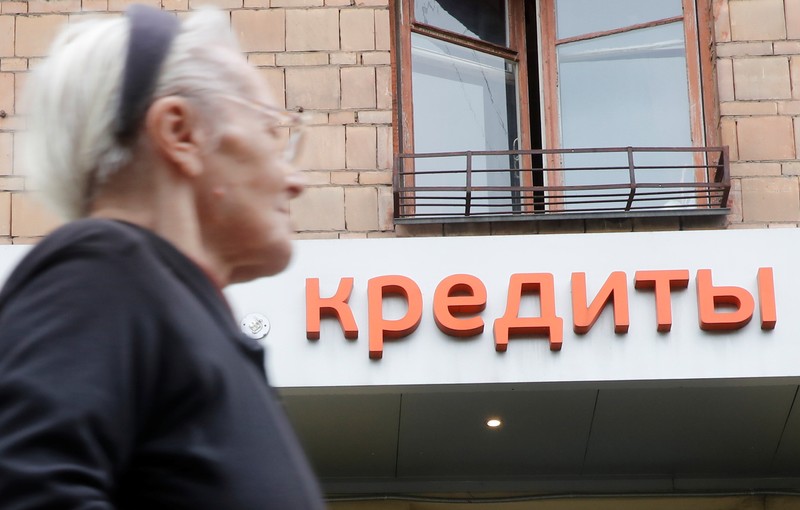 A woman walks past an office of a local bank in Moscow