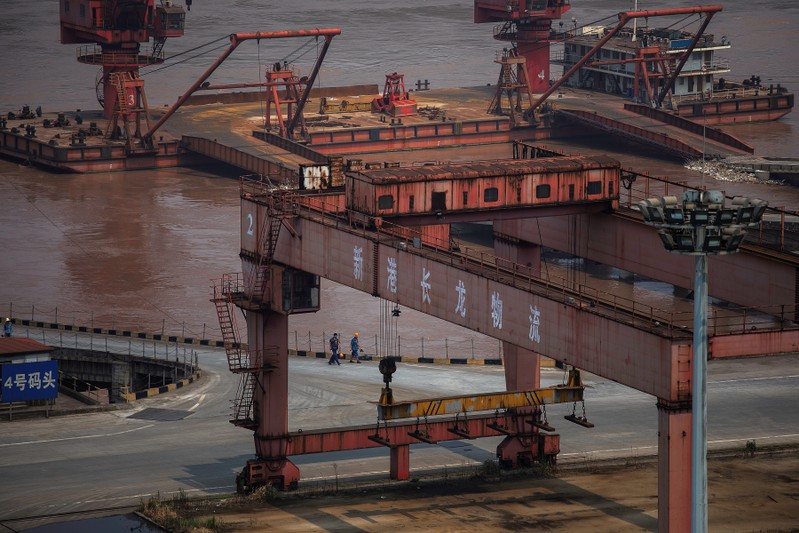 Workers walk at a dock dedicated for Chongqing Iron and Steel on the Yangtze river in Changshou
