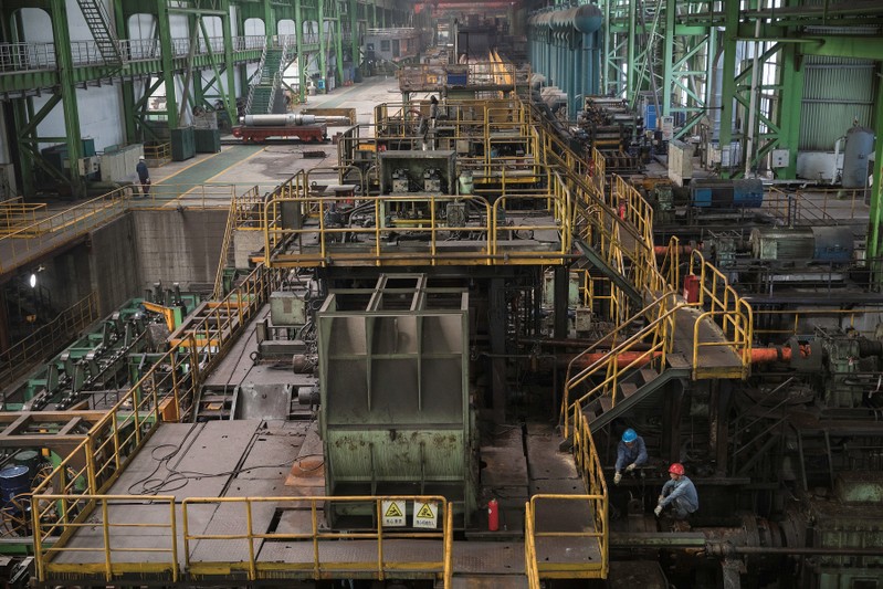 Workers are seen at a hot rolling production line at the Chongqing Iron and Steel plant in