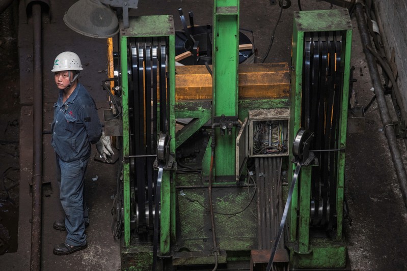 Worker stands at a hot rolling production line at the Chongqing Iron and Steel plant in