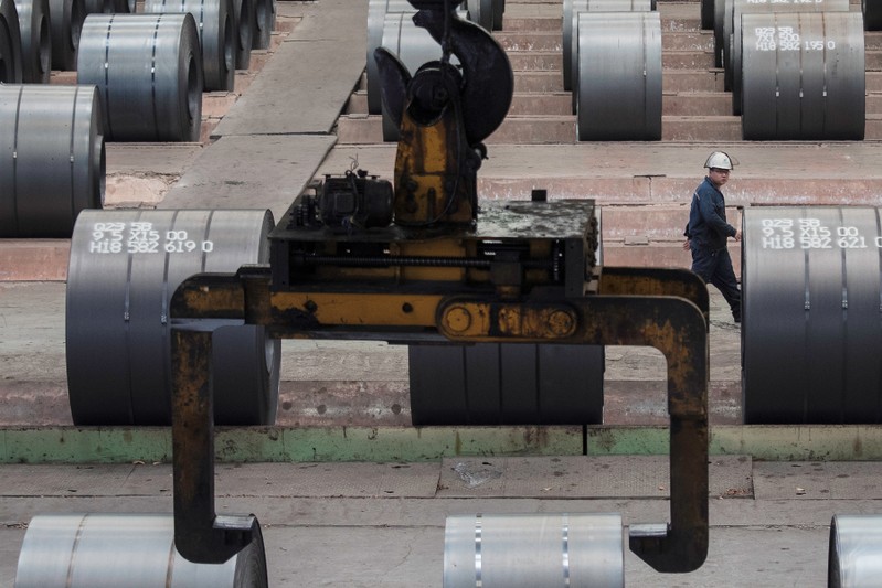 Worker walks past steel rolls at the Chongqing Iron and Steel plant in Changshou