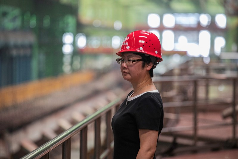 Woman looks on at the Chongqing Iron and Steel plant in Changshou