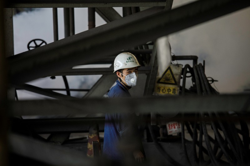 Worker looks on near smoke from blast furnace at the Chongqing Iron and Steel plant in