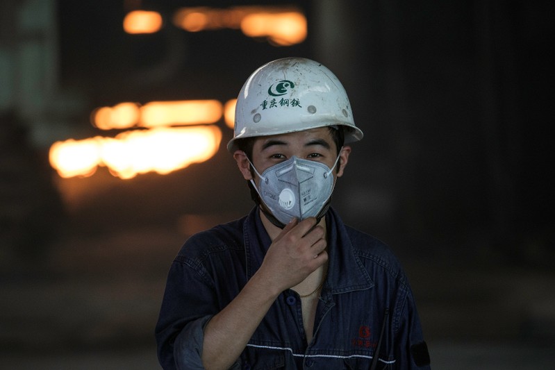 Worker adjusts his masks near a blast furnace at the Chongqing Iron and Steel plant in