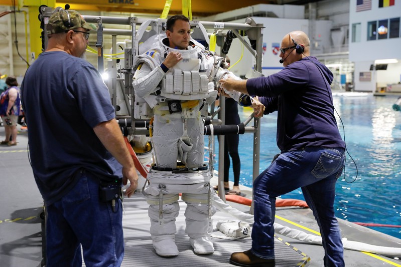 NASA Commercial Crew Astronaut Josh Cassada is helped to get into his space suit at NASA's