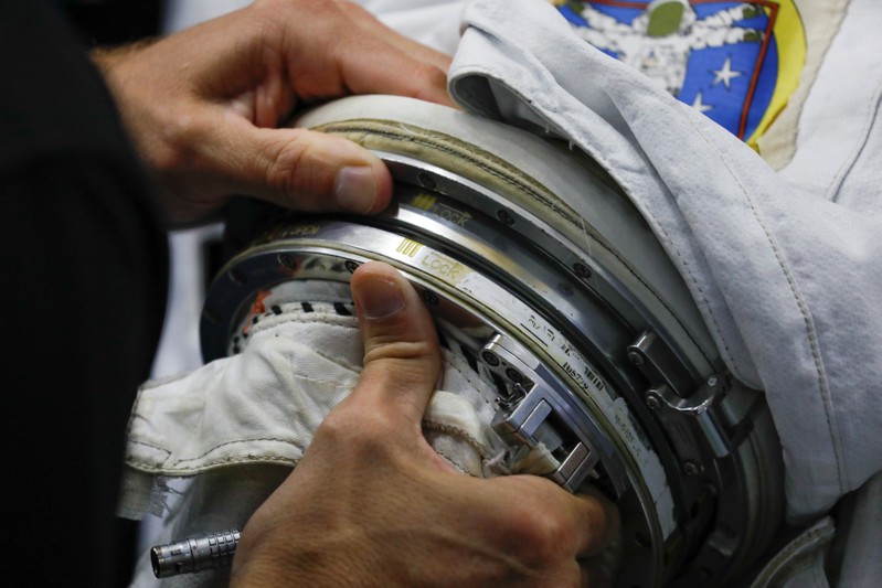 NASA Commercial Crew Astronaut Josh Cassada adjusts the arm during a space suit fitting session