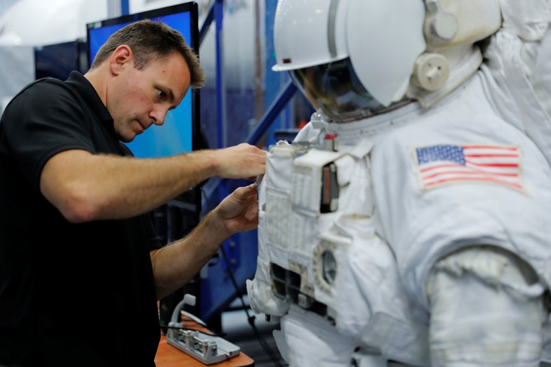 NASA Commercial Crew Astronaut Josh Cassada adjusts the length of an arm during a space suit