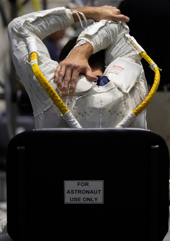 NASA Commercial Crew Astronaut Josh Cassada stretches before being placed into his space suit