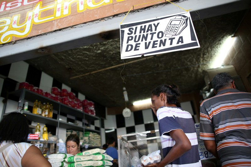 Customers buy products at a store in Caracas