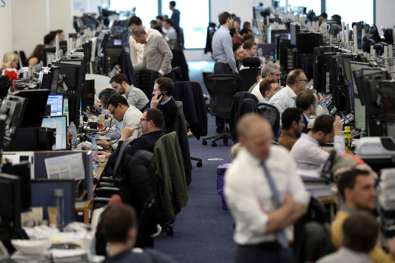 FILE PHOTO: Traders work on the trading floor of Barclays Bank at Canary Wharf in London