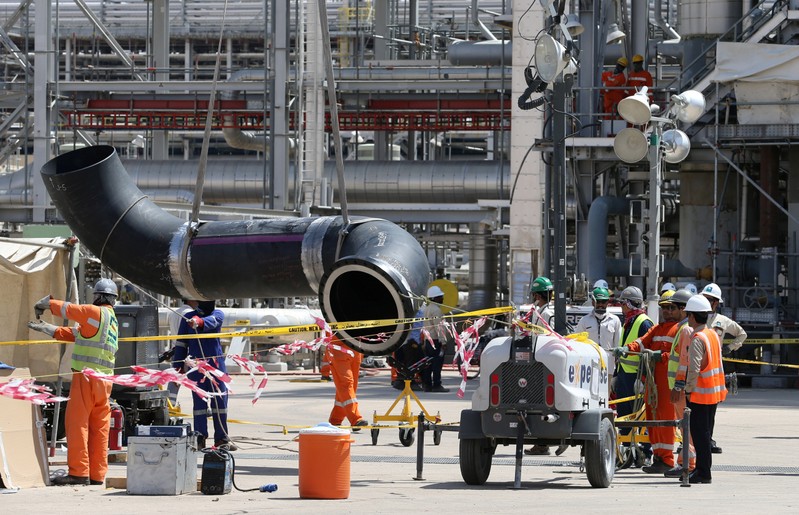 Workers fix a pipeline at the damaged site of Saudi Aramco oil facility in Khurais