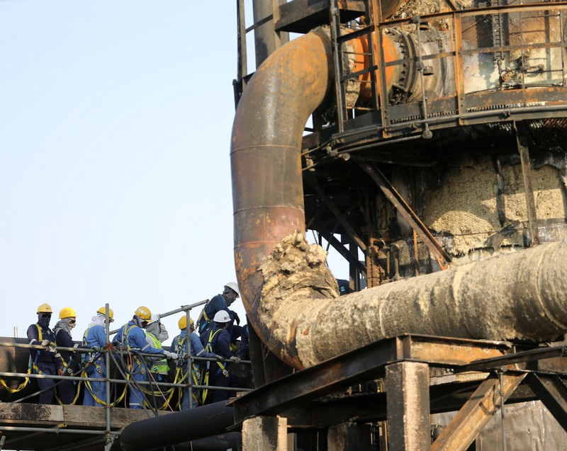 Workers repair the pipeline at the damaged site of Saudi Aramco oil facility in Abqaiq