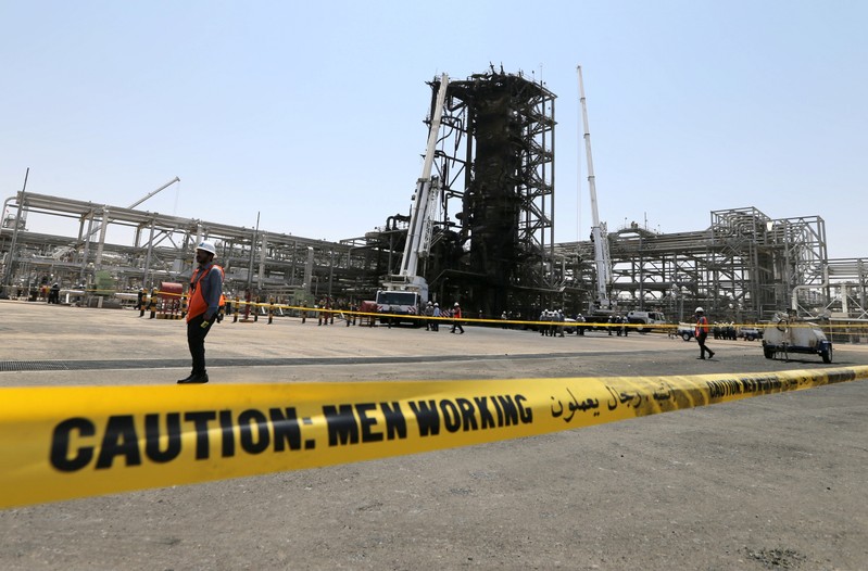 Workers are seen at the damaged site of Saudi Aramco oil facility in Khurais