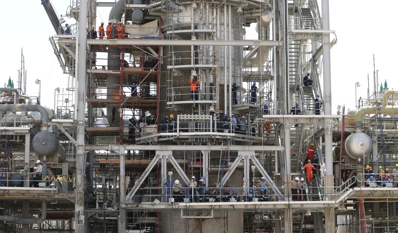 Workers are seen at the damaged site of Saudi Aramco oil facility in Khurais