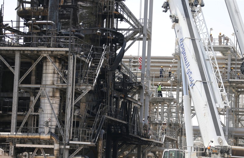 Workers are seen at the damaged site of Saudi Aramco oil facility in Khurais