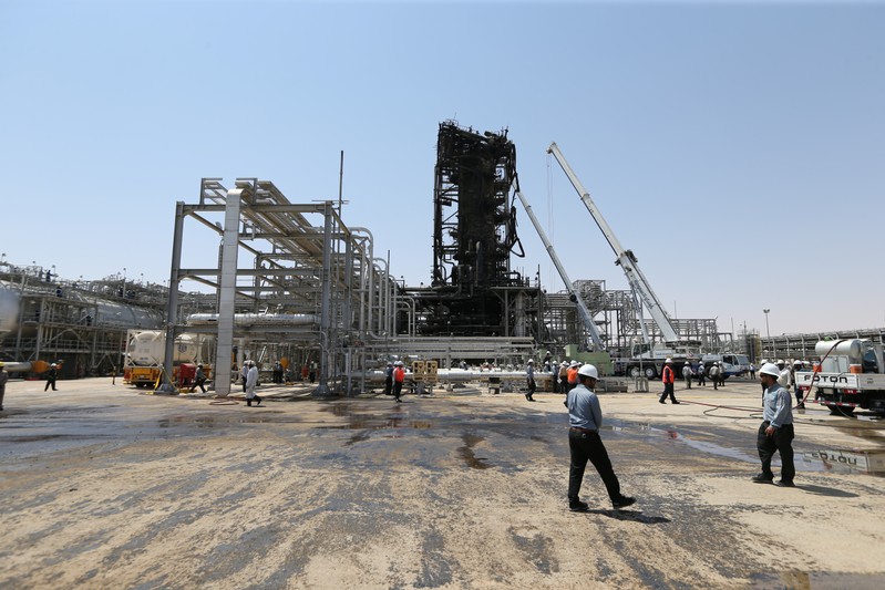 Workers are seen at the damaged site of Saudi Aramco oil facility in Khurais