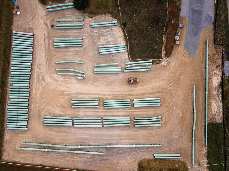 An aerial view shows lengths of pipe in a staging area for the construction of the Mountain